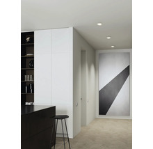 Moderne gangverlichting met drie inbouwspots in het plafond, minimalistische inrichting met groot kunstwerk op de muur.