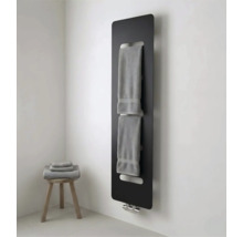 Moderne zwarte paneelradiator met geïntegreerde handdoekhouder in een lichte badkamer met houten krukje en handdoeken.