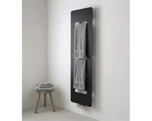 Moderne zwarte paneelradiator met geïntegreerde handdoekhouder in een lichte badkamer met houten krukje en handdoeken.