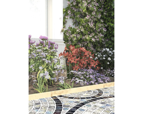 Tuinborder met bloemen, beschermd door een fijnmazig zwart beschermnet over een lichte houten rand langs een geplaveid pad.