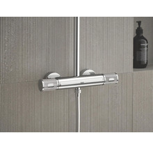 Grohe douchethermostaat van chroom met twee gestructureerde grepen en 38 graden markering gemonteerd op een getegelde wand.
