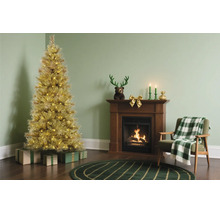 Gouden kerstboom met verlichting naast een houten open haard en een fauteuil met een geruite deken.
