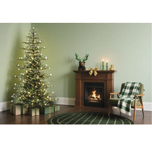 Feestelijk ingerichte woonkamer met verlichte kerstboom, cadeaus, houten open haard met brandend vuur en een fauteuil met geruite deken.