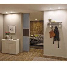 Moderne kamer met een wit dressoir, glazen schuifdeur en doorkijk naar de slaapkamer met wandkapstok in de gang.