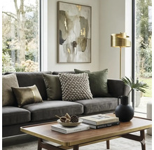 Lichte woonkamer met grijze bank, sierkussens, houten salontafel met gouden rand, gouden vloerlamp en abstract schilderij.