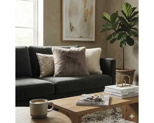 Moderne woonkamer met donkergrijze bank, sierkussens, houten salontafel en een grote kamerplant.