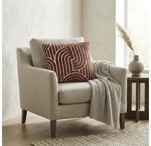 Moderne fauteuil met lichte stoffen bekleding, sierkussen met patroon en gebreide deken in een lichte woonkamer.