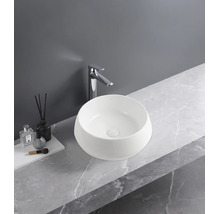 Moderne badkamer met ronde opzetwastafel van wit keramiek, een hoge chromen kraan en een wastafelblad met grijze marmerlook.