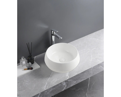 Moderne badkamer met ronde opzetwastafel van wit keramiek, een hoge chromen kraan en een wastafelblad met grijze marmerlook.