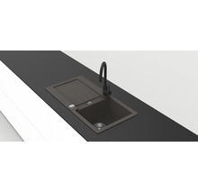 Moderne zwarte inbouwspoelbak van composiet met afdruipgedeelte en hoge zwarte kraan in een donker werkblad.