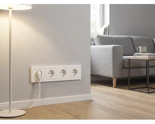 4-voudige wandcontactdoos met randaarde in een lichte, moderne woonkamer met bank, bijzettafel en vloerlamp.