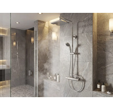Modern douchesysteem met regendouche, handdouche en thermostaatkraan in een betegelde douche met steeneffect.