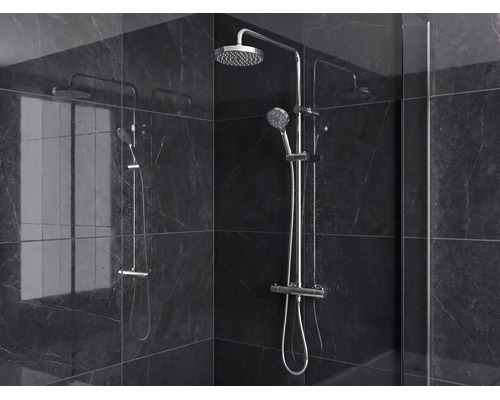 Modern douchesysteem met regendouche, handdouche en thermostaat tegen donkere tegels met marmerlook.