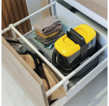 Compacte Powerplus tapijtreiniger georganiseerd opgeborgen in een lade met gevouwen handdoeken. Powerplus Logo.