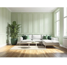 Lichte woonkamer met groene wandpanelen, witte bank, houten vloer en grote kamerplant. Modern design met decoratieve wandlijsten.