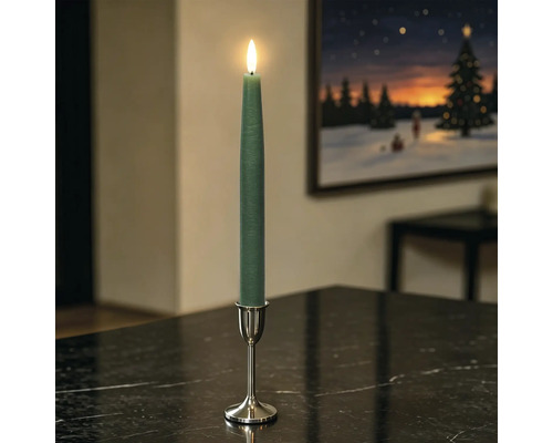 Groene LED-dinerkaars met bewegende vlam in zilveren kandelaar op een donkere tafel in een woonkamer.