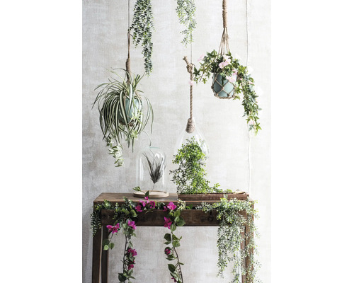 Decoratieve kunstmatige hangplanten, terraria en bloemranken op een houten sidetable.