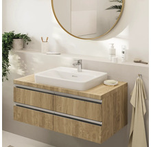 Moderne badkamer met een zwevend wastafelmeubel in houtlook, witte opbouwwastafel, chromen kraan en een grote ronde spiegel.