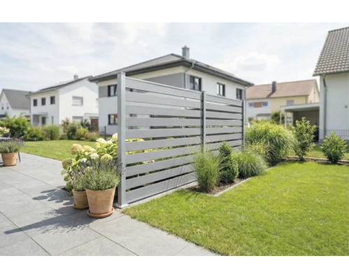Modern horizontaal lamellenhekwerk in een verzorgde tuin met terras, gazon en plantenbakken.