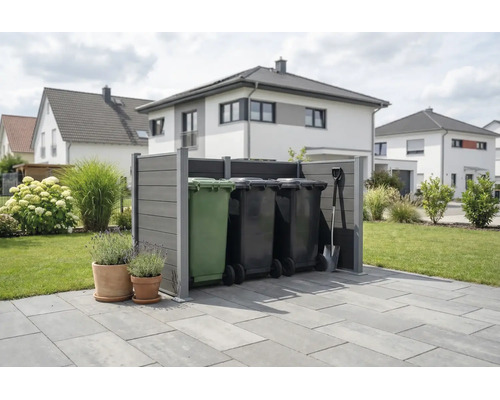Moderne grijze afvalcontainer ombouw van composiet op een terras in een georganiseerde tuin met woonhuizen op de achtergrond.