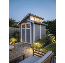 Modern houten tuinhuis in grijs met witte omlijsting, openslaande deuren met ramen en bovenlichten in een verlichte tuin.
