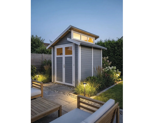 Modern houten tuinhuis in grijs met witte omlijsting, openslaande deuren met ramen en bovenlichten in een verlichte tuin.