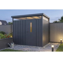 Modern metalen tuinhuis in antraciet met plat dak en lichtkoepels in een verlichte tuin.