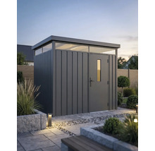 Modern metalen tuinhuis met plat dak en bovenlichten in een georganiseerde tuin met stenen tegels en planten.