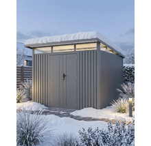 Moderne grijze metalen berging met lessenaarsdak, bovenlichten en dubbele deur in een besneeuwde tuin.