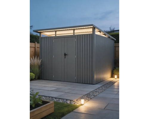 Modern metalen tuinhuis met lessenaarsdak, bovenlichten en dubbele deur op een bestraat oppervlak in een helder verlichte tuin.