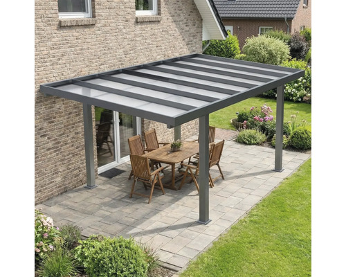 Moderne terrasoverkapping van antraciet aluminium met een lichtdoorlatend dak op een bestraat terras met tuinmeubilair.