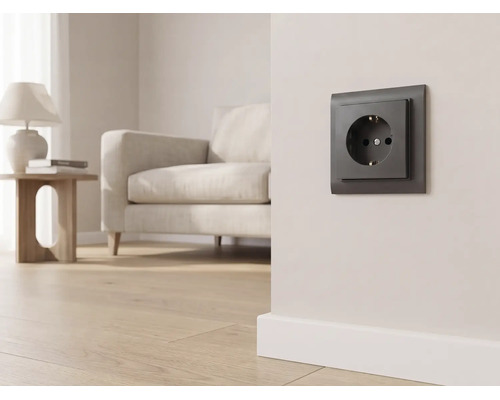 Donker stopcontact op een lichte wand in een modern ingerichte woonkamer met een bank en parketvloer.