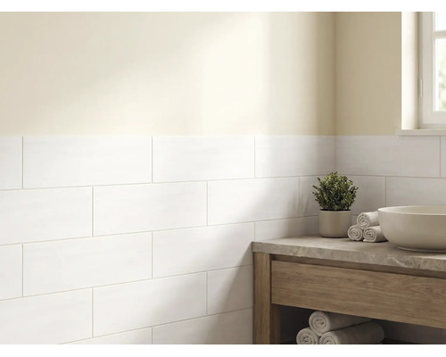 Lichte badkamer met witte rechthoekige wandtegels in halfsteensverband, een houten wastafelmeubel met stenen blad en een waskom.