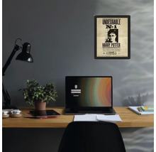 Ingelijste Harry Potter poster Undesirable nummer 1 aan een grijze muur boven een georganiseerd houten bureau met laptop en lamp.