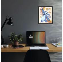 Ingelijste poster met Disney-personage Stitch en tekst Let's Dance boven een bureau met laptop en lamp in een modern ingerichte werkkamer.