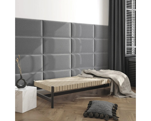 Moderne kamer met rechthoekige gestoffeerde wandpanelen aan de muur boven een ligbed met visgraatparket.