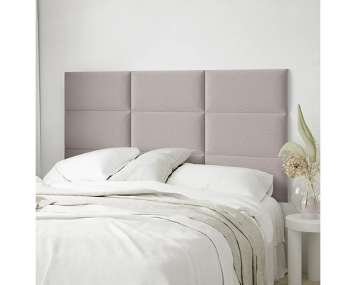 Lichte slaapkamer met bed en gepolsterde wandpanelen als hoofdbord, bestaande uit zes rechthoekige elementen met gestructureerde stoffen bekleding.