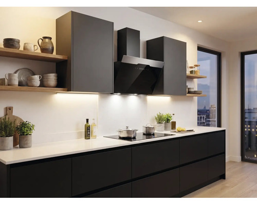 Moderne keuken met donkere fronten, wit werkblad, zwarte afzuigkap en houten wandplanken.