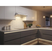 Moderne inbouwkeuken met witte bovenkastjes, grijze onderkastjes en geïntegreerde ledverlichting onder het aanrechtblad en bij de plint.