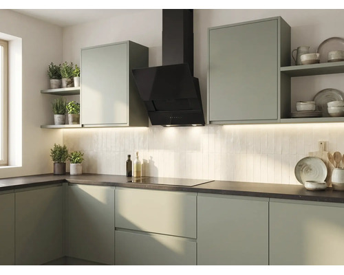 Moderne keuken in olijfgroen met zwarte afzuigkap, lichte verticale tegels en een donker werkblad.