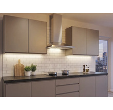Moderne inbouwkeuken met greeploze fronten, roestvrijstalen afzuigkap, donker werkblad en witte tegelwand.
