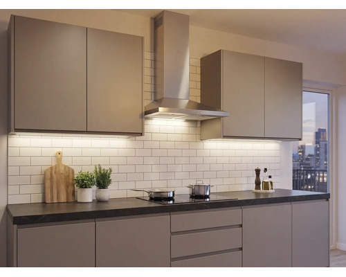 Moderne inbouwkeuken met greeploze fronten, roestvrijstalen afzuigkap, donker werkblad en witte tegelwand.
