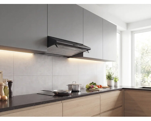 Zwarte onderbouw afzuigkap in een moderne keuken met grijze bovenkasten, houten onderkasten en kookgerei op de kookplaat.