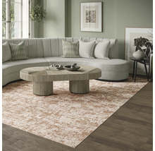 Moderne woonkamer met groot tapijt met abstract patroon in beige en bruin, een lichtgekleurde ronde bank en een houten salontafel.