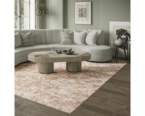 Moderne woonkamer met groot tapijt met abstract patroon in beige en bruin, een lichtgekleurde ronde bank en een houten salontafel.