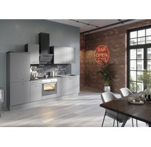 Moderne grijze keuken in loftstijl met inbouwapparatuur voor een bakstenen muur met neonbord en een eettafel op de voorgrond.