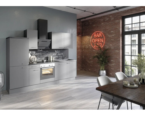 Moderne grijze keuken in loftstijl met inbouwapparatuur voor een bakstenen muur met neonbord en een eettafel op de voorgrond.