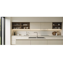 Moderne lichte keuken met minimalistische kasten, kookeiland, roestvrijstalen spoelbakken, kranen en open houten planken met onderbouwverlichting.