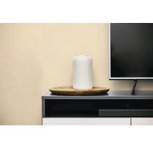 Gestructureerd behang in beige achter een donker dressoir met een witte vaas en een televisie.