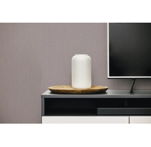 Gestructureerd behang met verticaal patroon in een moderne woonkamer achter een tv-meubel met vaas en houten schaal.
